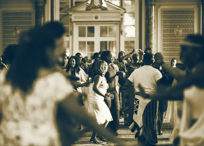 Guests dancing together while traditional dancers move through the room